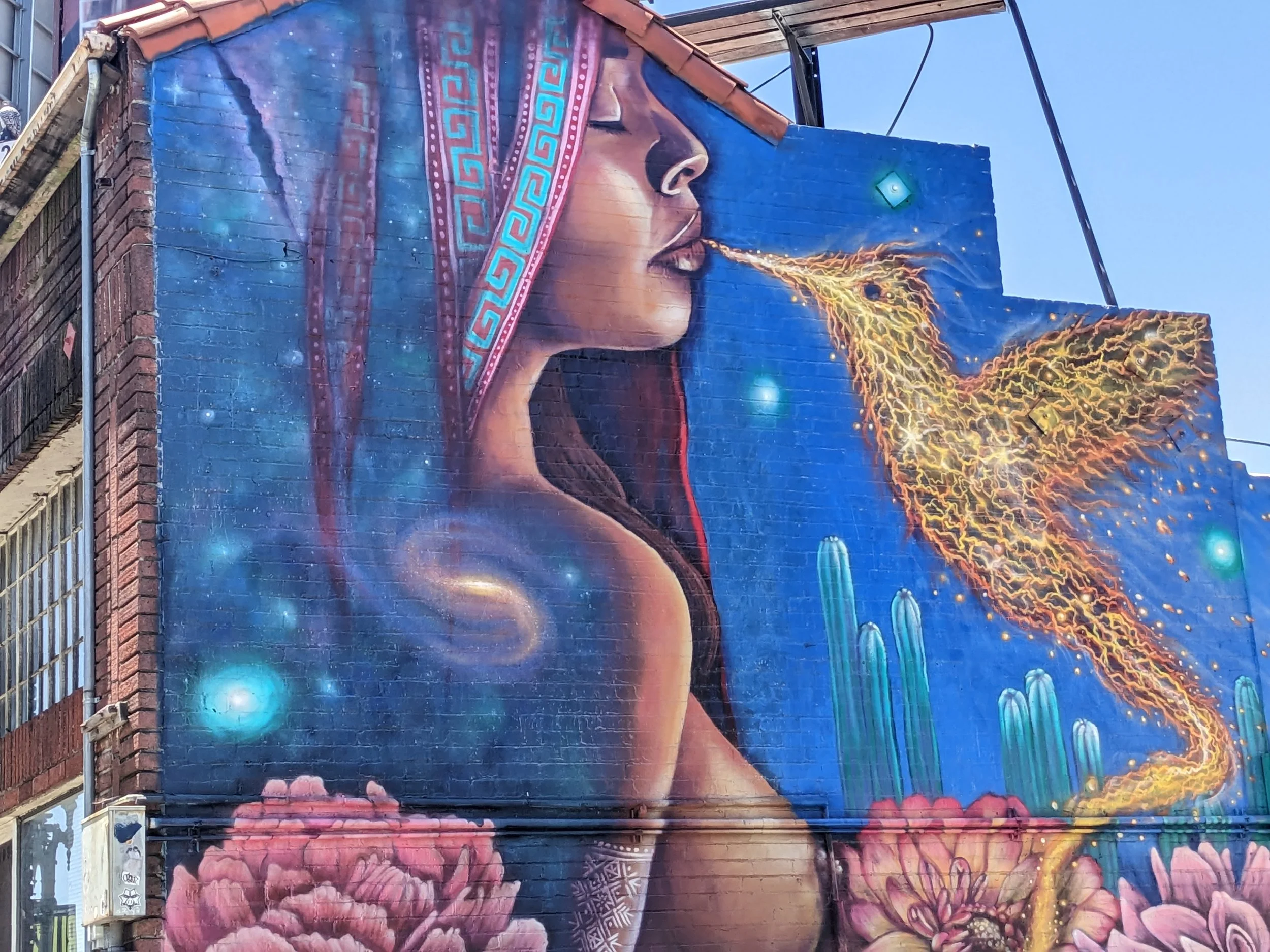 Mural of ethereal bird, rippling with energy, using its beak to touch the lips of a woman with her eyes closed