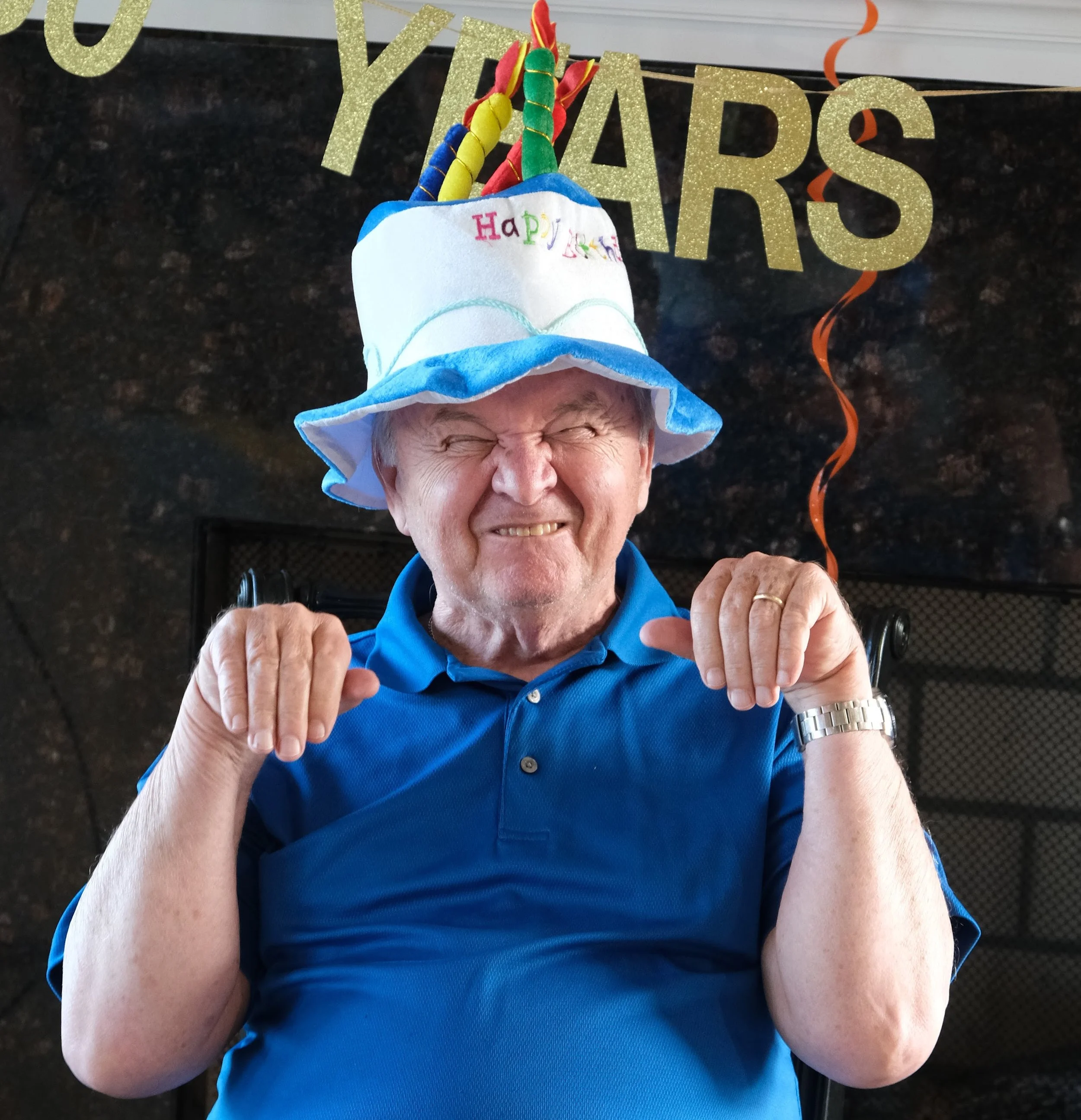 My Grampy making a funny face while wearing a birthday cake hat