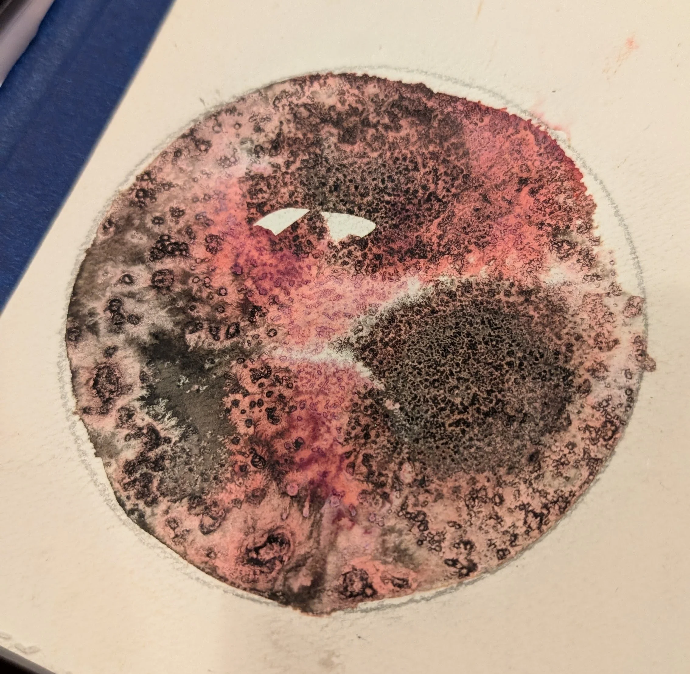 Red and brown splotches of watercolor on a page