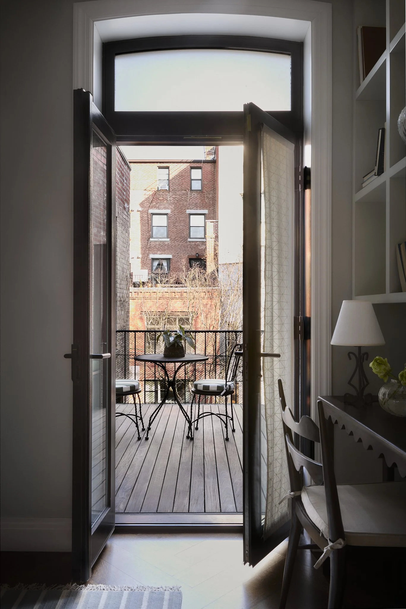 Brooklyn Heights townhouse interior by Hallie Rose Design opening onto a private balcony with café seating and layered residential styling.