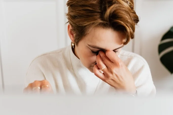 A woman with her hand over her face