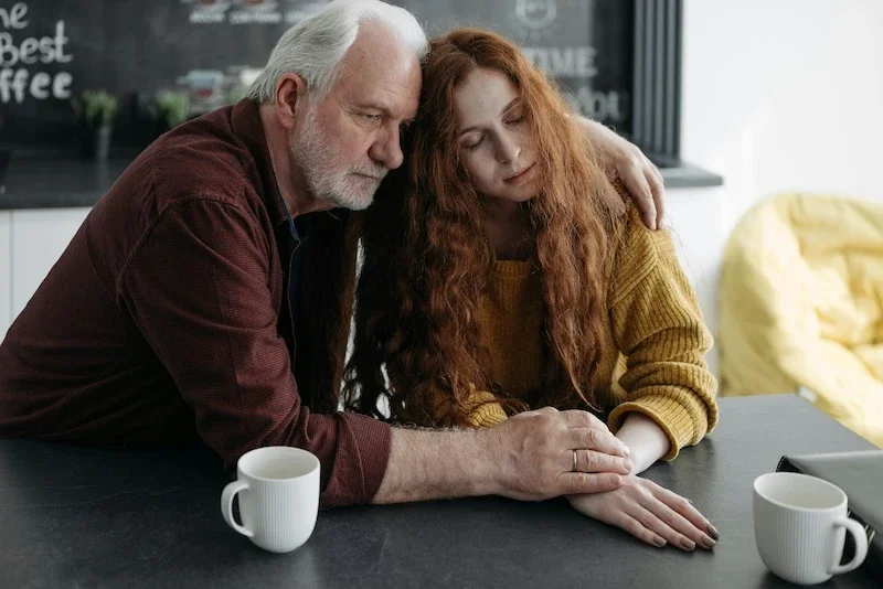 a father comforting his daughter