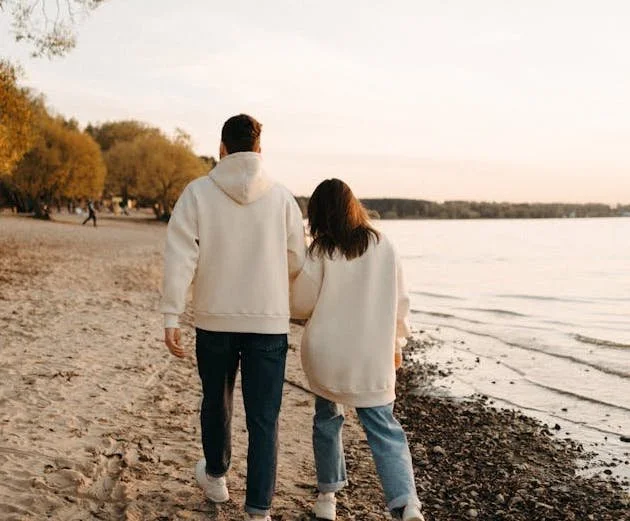 a cople walking along the beach