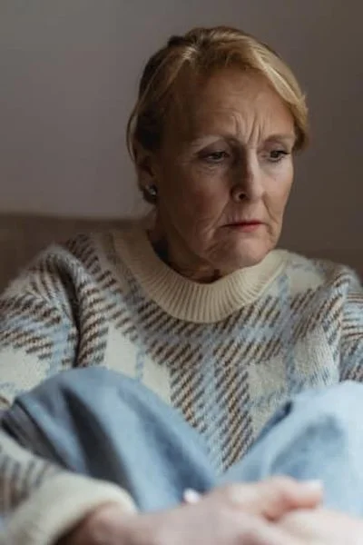 a older woman on the couch looking down