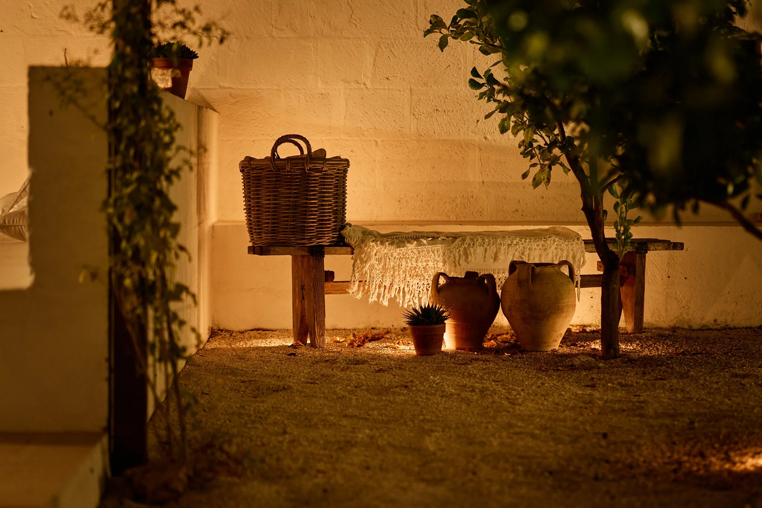 Een met kaarsen verlicht bankje in de citroen boomgaard van Borgo Gallana.
