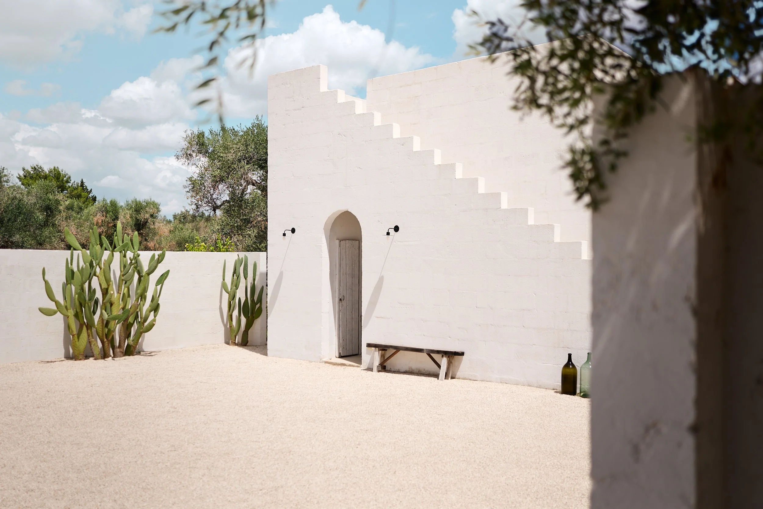 Wit appartement met trap aan buitenkant en bankje voor de deur.