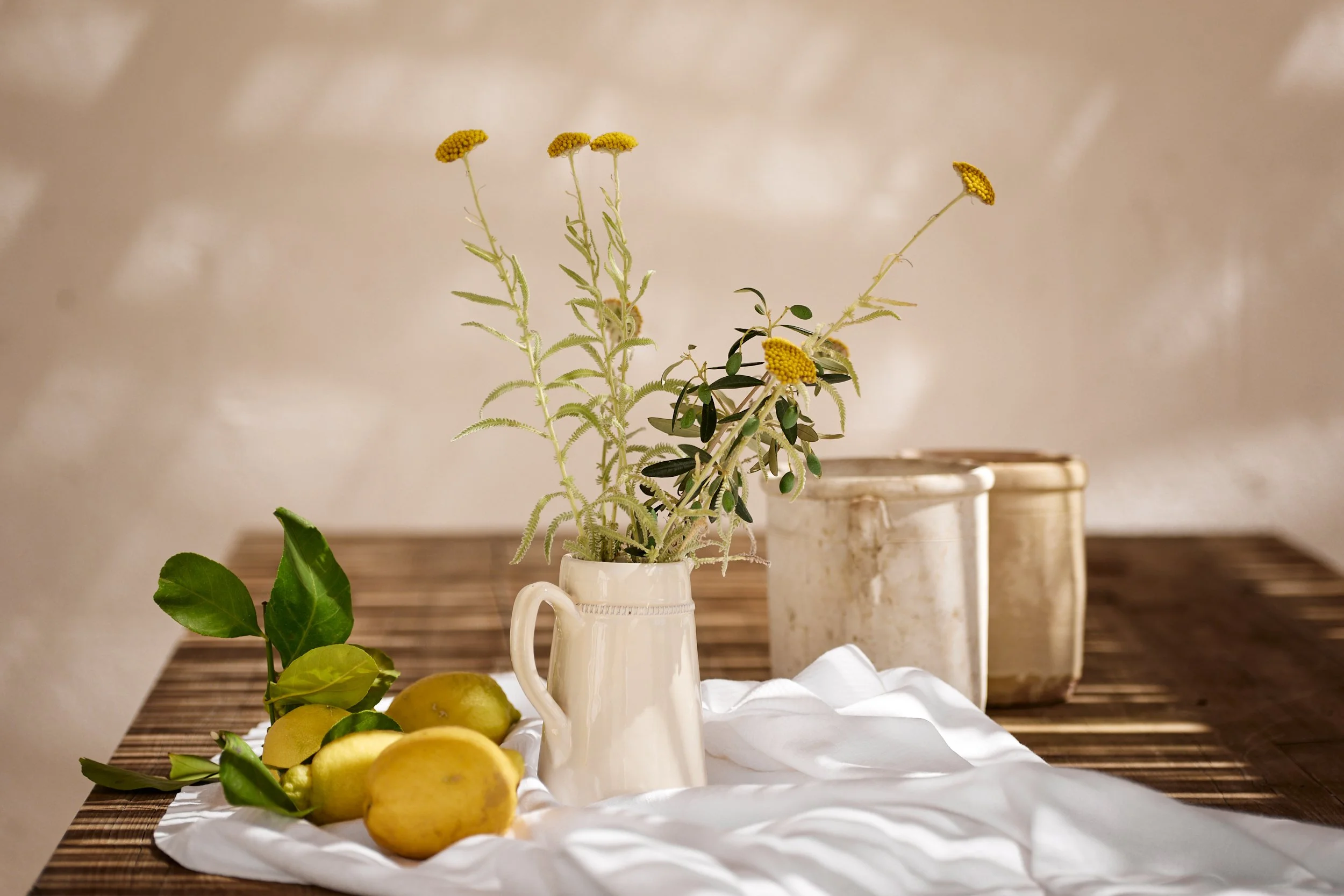 Sfeervol aangeklede tafel met kannen gevuld met bloemen uit de tuin.