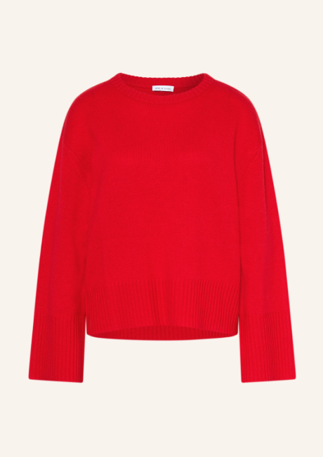 Roter Langarm Pullover aus Feinstrick mit Rundhalsausschnitt. Lockerer Strickpullover mit überschnittenen Schultern vor hellem Hintergrund. Breite Rippbündchen an weiten Ärmelenden und Saum.