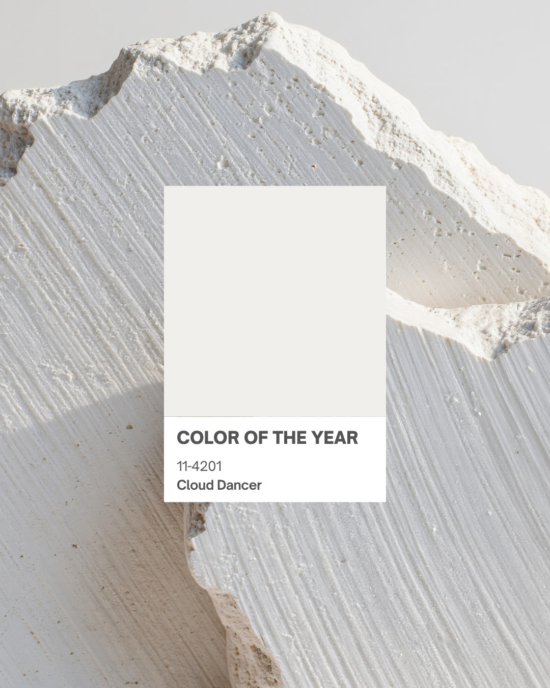 Farbkarte der Trendfarbe 2026 „Cloud Dancer“ (Pantone 11-4201) vor weißer Naturstein-Textur. Symbolbild für aktuelle Modetrends.