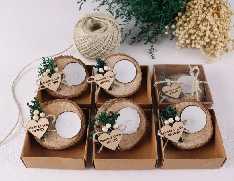 Rustikale Hochzeit-Gastgeschenke: Handgefertigte Teelichthalter aus Holzscheiben, dekoriert mit Trockenblumen, Grün und personalisiertem Holzherz „Kelsey & Collin“ — perfekt für Boho- und Waldhochzeiten.