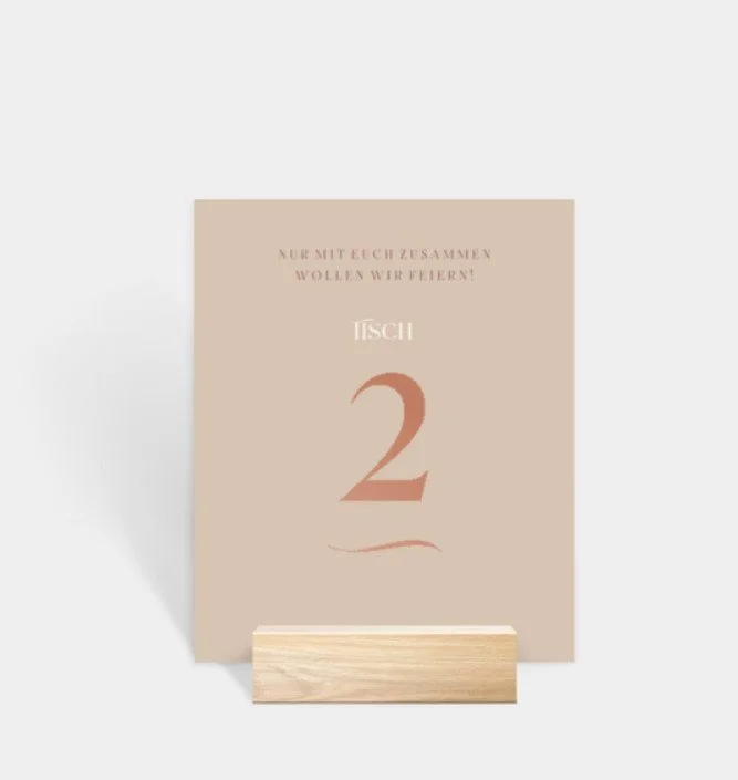  Eine elegante Karte in einem sanften Beigeton mit der Aufschrift „TISCH 2“ und einem romantischen Spruch, gehalten in einem hellen Holzblock. 
