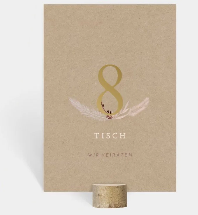  Eine quadratische Karte aus Kraftpapier mit der goldenen Nummer „8“ und zarten Feder-Illustrationen. 