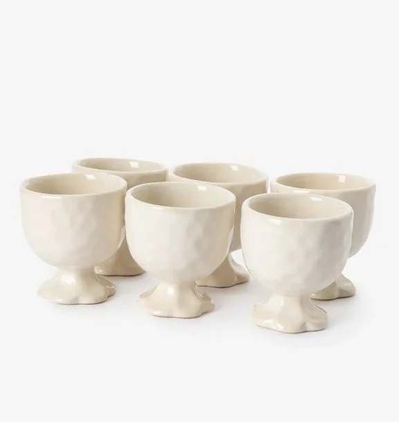 Set aus sechs cremefarbenen Keramik-Eierbechern von Sissy-Boy mit unregelmäßiger Struktur und einem blumenförmigen Fuß.