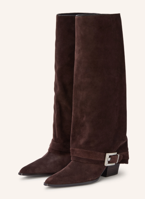 Ein Paar hohe, dunkelbraune Wildlederstiefel mit spitzer Kappe, weitem Schaft, niedrigem Blockabsatz und einem Riemen mit silberner Schnalle am Knöchel.