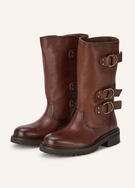 Wadenhohe braune Lederstiefel mit drei dekorativen Schnallen und robuster Profilsohle vor hellem Hintergrund.