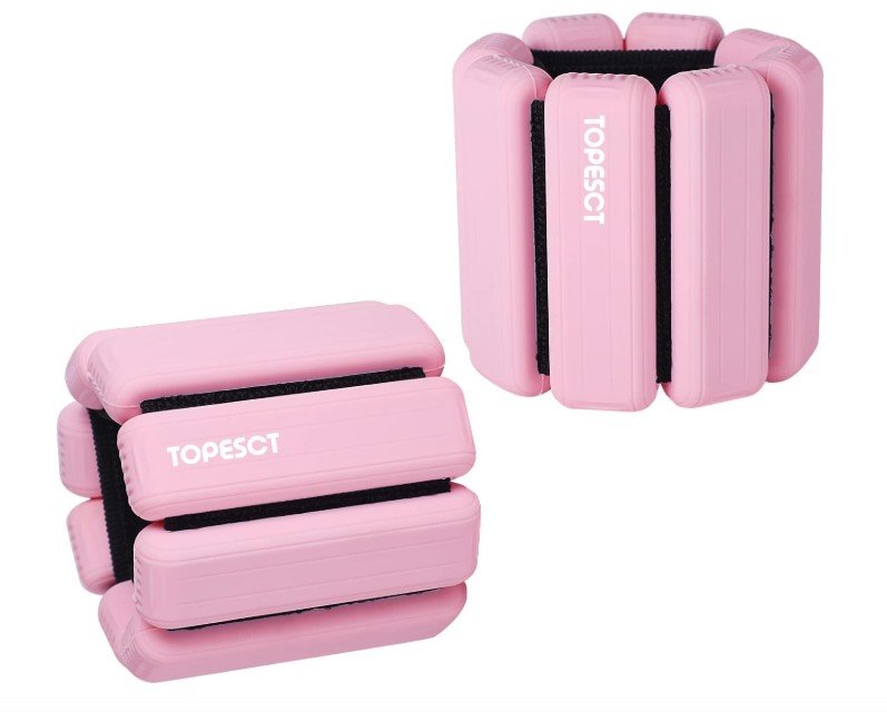 Rosa verstellbare Fitness-Handgewichte mit Klettverschluss für Handgelenke und Knöchel auf weißem Hintergrund.