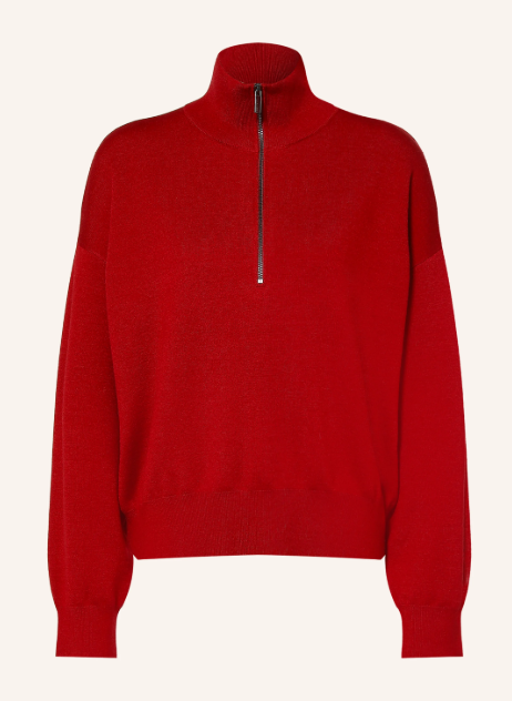 Roter Troyer Pullover aus Feinstrick mit hohem Stehkragen und halblangem silbernem Reißverschluss vor hellem Hintergrund. Langarm Strickpullover mit überschnittenen Schultern und Rippbündchen.