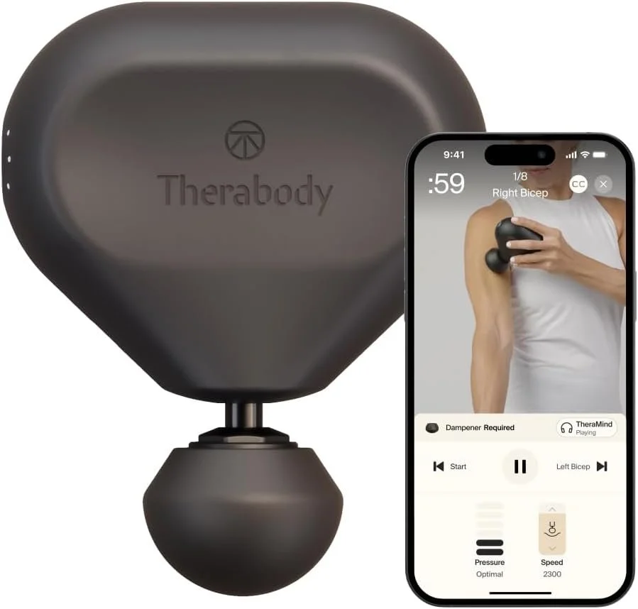 Ein dunkles Theragun-Massagegerät in Dreiecksform neben einem Smartphone, auf dessen Display eine App die Anwendung am Bizeps zeigt.