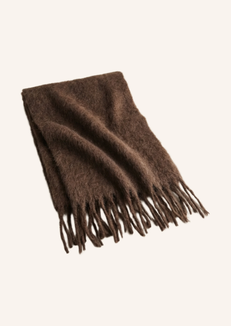 Gefalteter, dunkelbrauner Schal aus flauschigem, weichem Material. An den unteren Kanten des Accessoires fallen lange, gezwirnte Fransen herab.