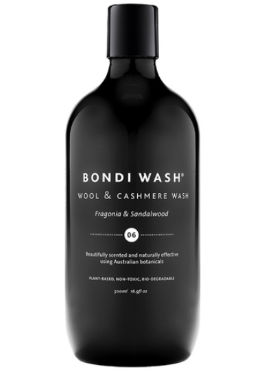 Eine elegante, komplett schwarze Flasche des Spezialwaschmittels „Wool & Cashmere Wash“ der Marke Bondi Wash. Die weiße Aufschrift hebt die Duftrichtung Fragonia und Sandelholz sowie die natürliche, pflanzliche Zusammensetzung hervor.
