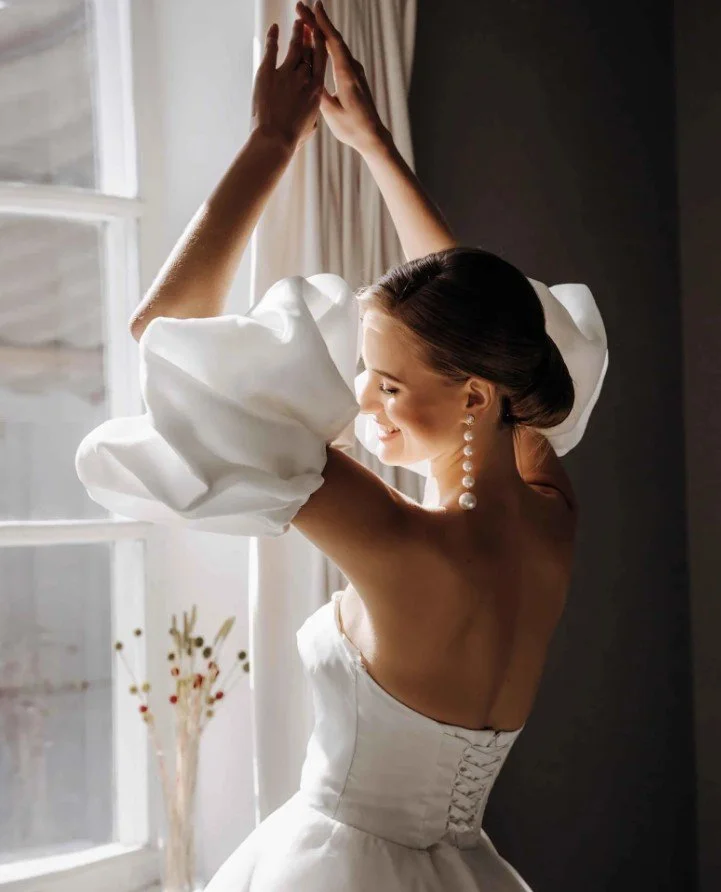 Modernes Satin-Brautkleid mit Rückenschnürung und riesigen Statement-Puffärmeln.
