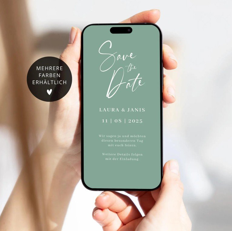 Eine Person hält ein Smartphone. Auf dem Display: salbeigrüne Save‑the‑Date‑Karte mit weißer Schrift: „Save the Date“, Laura & Janis, 11.08.2025. Links ein schwarzer Kreis: „Mehrere Farben erhältlich“ mit weißem Herz.