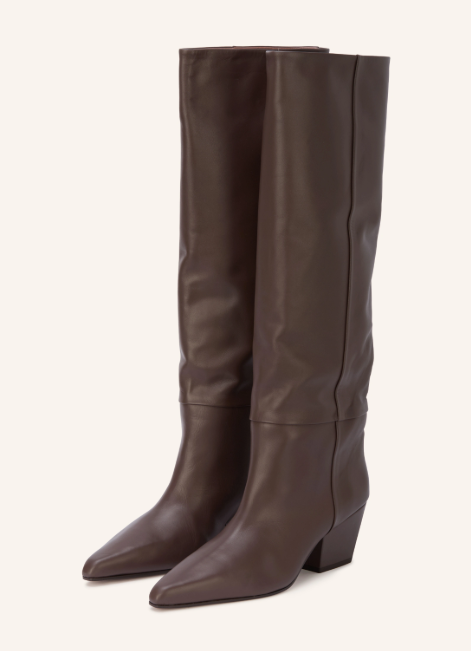 Ein Paar kniehohe Damenstiefel aus dunkelbraunem Glattleder, mit spitz zulaufender Zehenkappe und abgeschrägtem Blockabsatz, vor einem hellen, cremefarbenen Hintergrund.