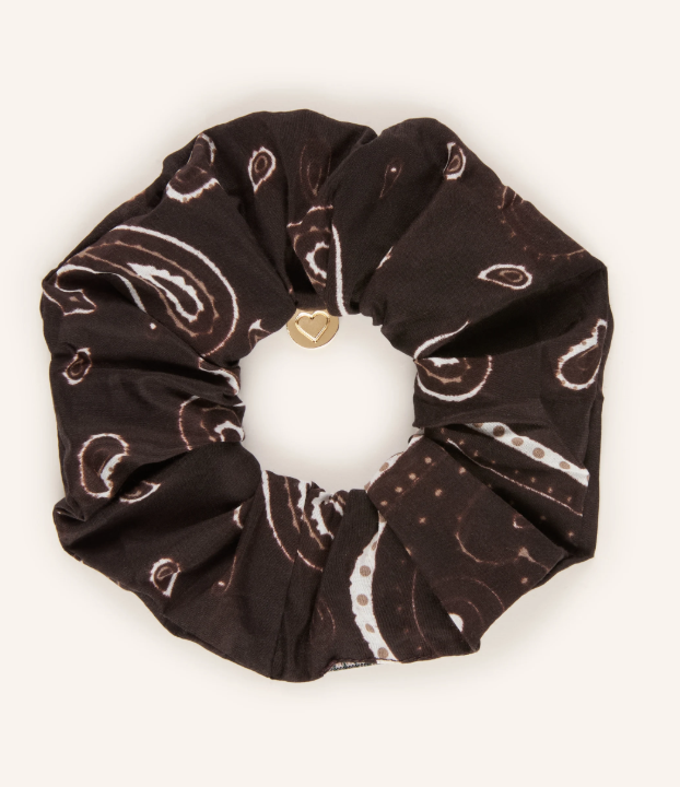 Dunkelbraunes Scrunchie mit cremefarbenem Paisley-Muster und goldenem, herzförmigem Zierknopf in der Mitte.