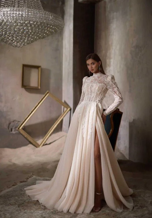 Elegantes, hochgeschlossenes Brautkleid mit langen Spitzenärmeln, detailliertem Mieder und einem fließenden Rock mit gewagtem Beinschlitz.