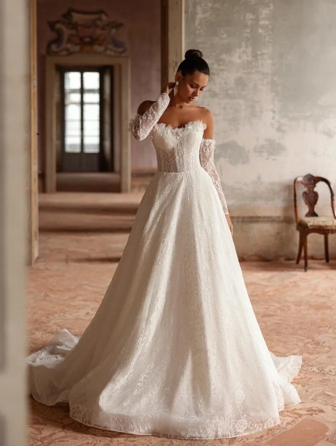 Romantisches Spitzen-Brautkleid mit Korsage und abnehmbaren, langen Spitzenärmeln.