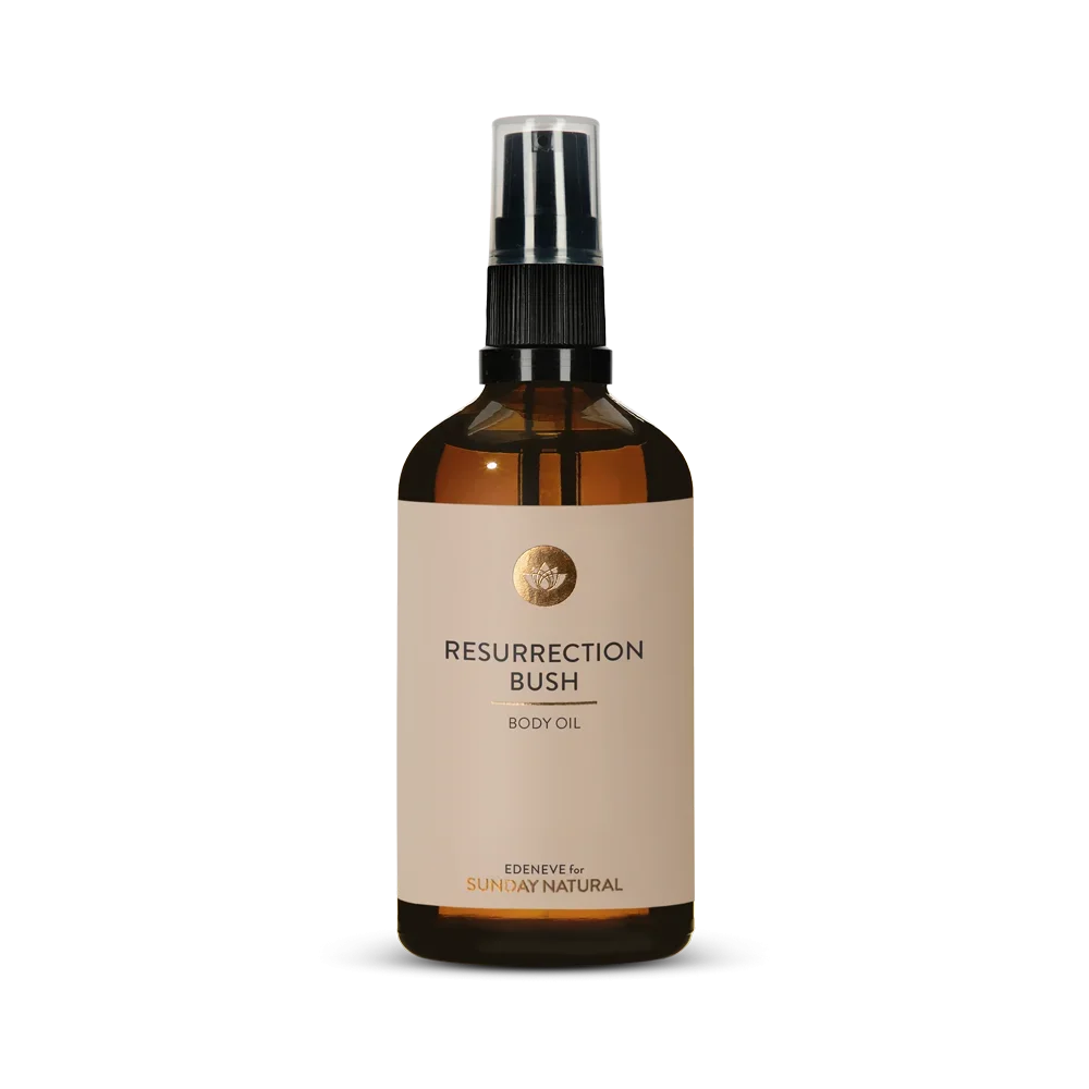 Braune Glasflasche mit schwarzem Pumpspender. Auf dem beigen Etikett steht in schwarzen und goldenen Buchstaben: "RESURRECTION BUSH BODY OIL". Darunter: "EDENEVE for SUNDAY NATURAL".