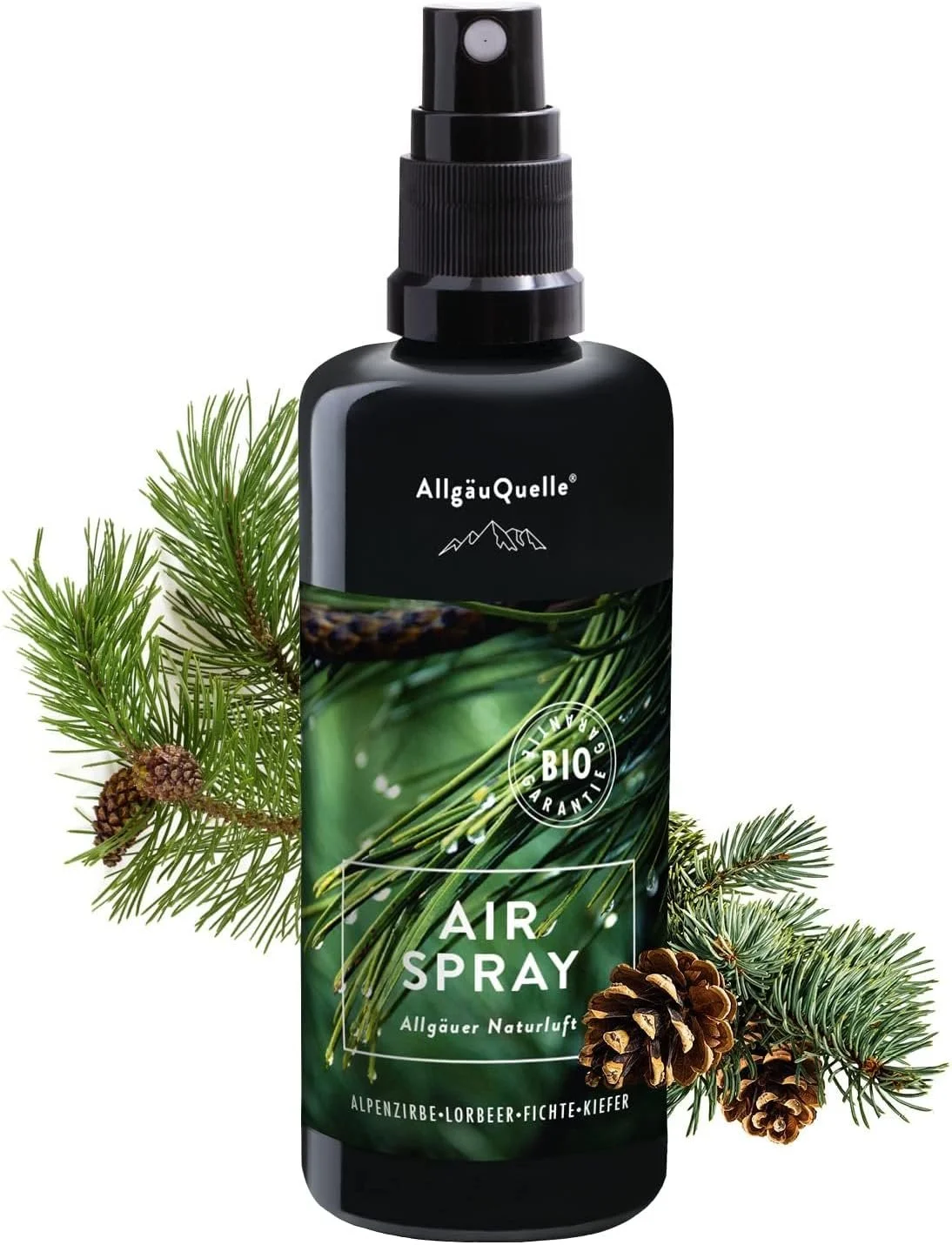 AllgäuQuelle "Air Spray" in schwarzer Flasche, flankiert von frischen Nadelbaumzweigen und kleinen Zapfen.