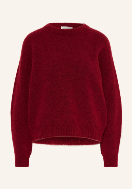 Dunkelroter Langarm Pullover aus flauschigem Grobstrick mit Rundhalsausschnitt. Lockerer Strickpullover vor hellem Hintergrund. Elastische Rippbündchen an Hals, Ärmelenden und breitem Saum.
