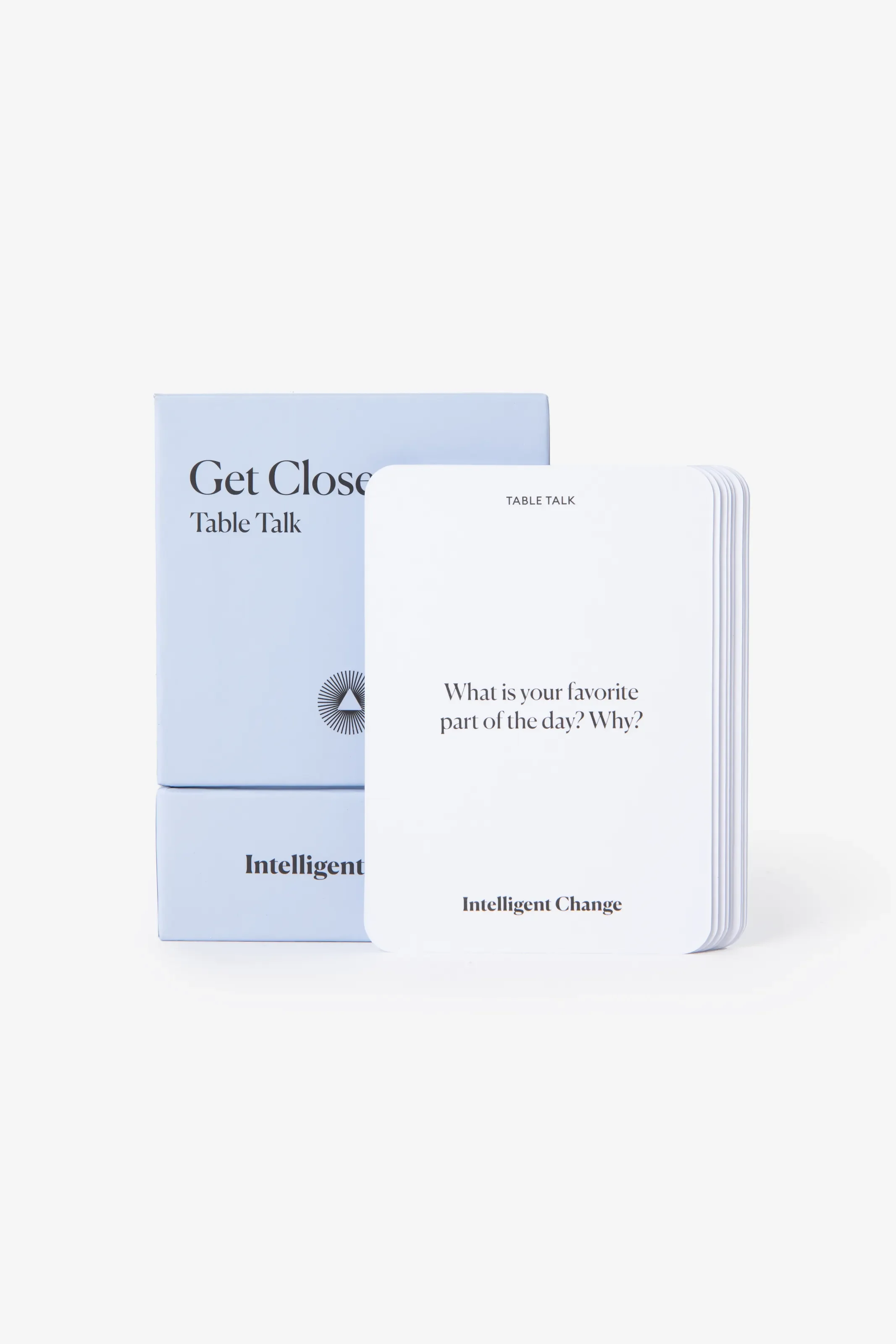 Hellblaue Box des Kartenspiels „Get Closer Table Talk“. Davor ein Kartenstapel. Die vorderste Karte fragt: „What is your favorite part of the day? Why?“.
