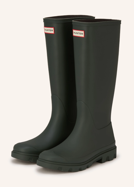 Ein Paar hohe, dunkelgrüne Gummistiefel von HUNTER. Oben am vorderen Schaft befindet sich das bekannte rot-weiße Logo, unten eine robuste Profilsohle.