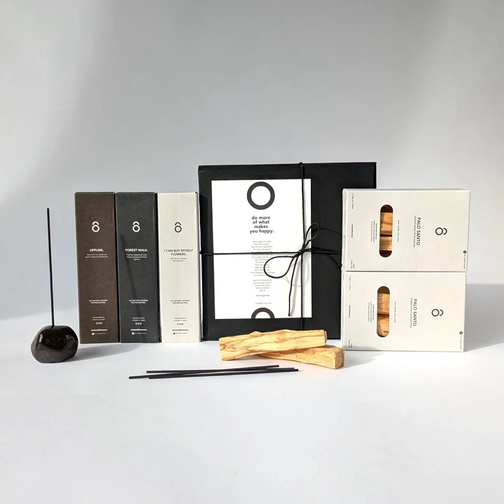 Achtsamkeits-Geschenkset mit drei Päckchen Räucherstäbchen, Palo Santo Holz, Steinhalter und einer schwarzen Geschenkbox mit der Karte „do more of what makes you happy“.