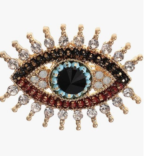 Goldfarbene Brosche in Augenform (Evil Eye/Auge der Fatima) mit großer schwarzer Kristallpupille, hellblauen Perlen, roten Akzenten und Wimpern aus funkelnden weißen Kristallen. Hochwertiger Broschenschmuck.