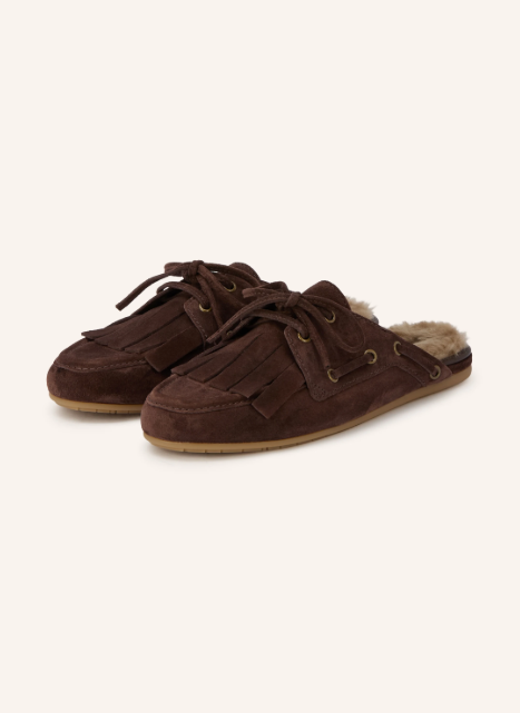 Dunkelbraune Veloursleder-Mules im Stil von Bootsschuhen mit Fransenlasche, Schnürung und wärmendem Lammfell-Innenfutter an der offenen Ferse.