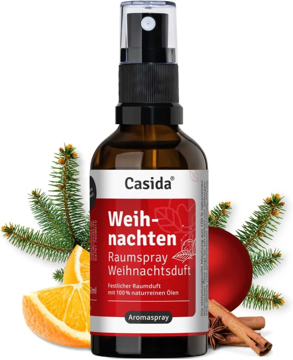 Casida Raumspray "Weihnachten" in Braunglasflasche, umgeben von Tannenzweigen, Orangen, Zimt und einer roten Weihnachtskugel.