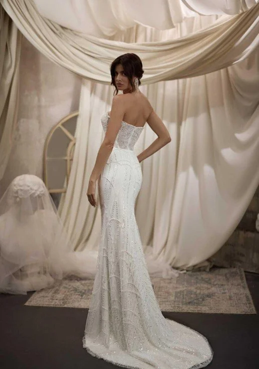 Figurbetontes, trägerloses Brautkleid (Fit and Flare) mit funkelnder, geometrischer Pailletten-Bestickung und transparenter Rückenkorsage.