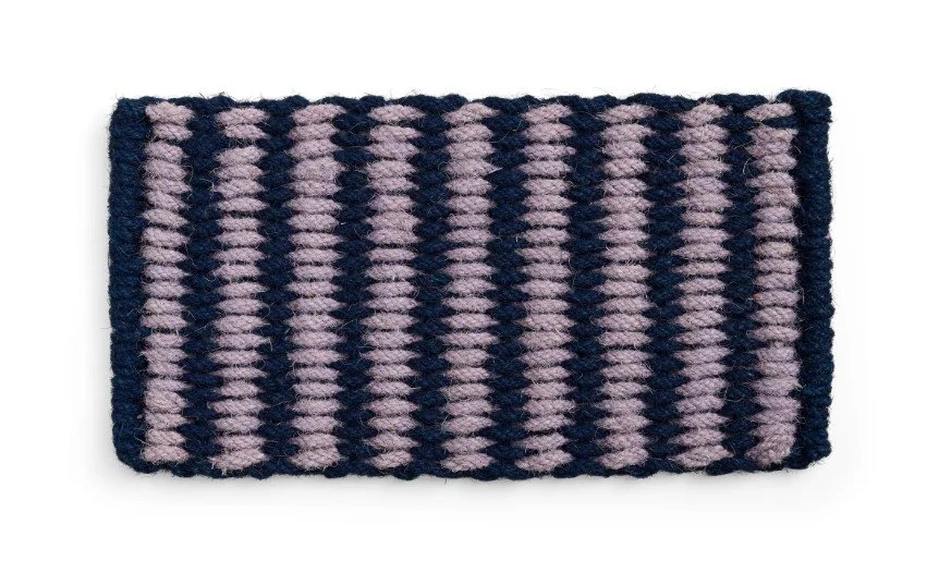 Robust gewebte Fußmatte aus dickem Tau in Dunkelblau und Flieder mit grober, strukturierter Oberfläche.