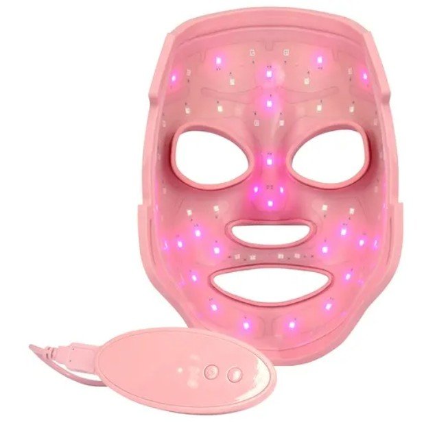 Innenansicht der MZ Skin LightMAX LED-Maske in Rosa. Das Bild zeigt die Anordnung der zahlreichen leuchtenden LED-Dioden auf der Innenseite sowie die passende Fernbedienung für die Steuerung der Lichtmodi.