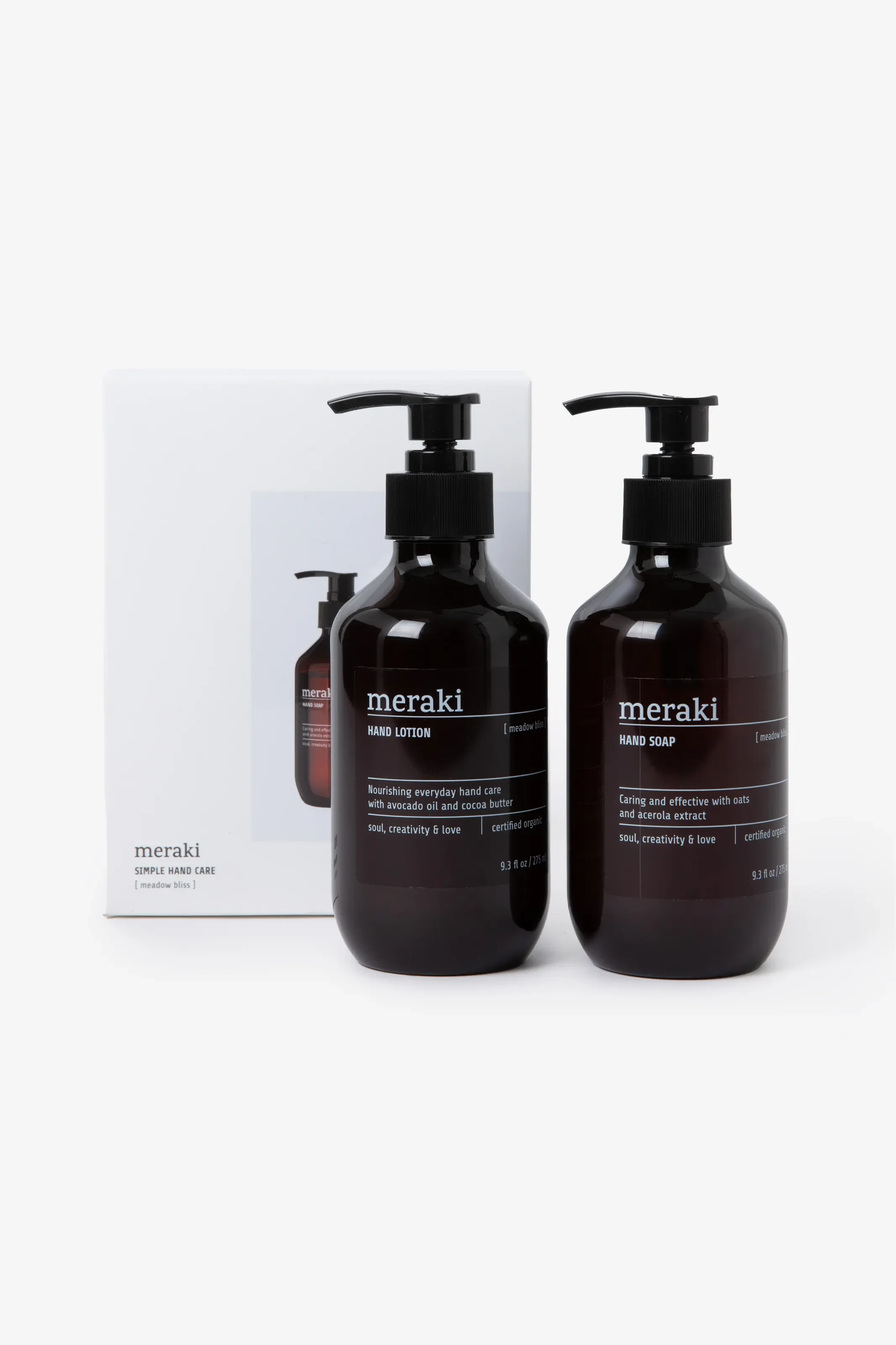 Geschenkset von meraki mit zwei dunkelbraunen Pumpspendern für Handlotion und Handseife der Sorte „meadow bliss“. Dahinter steht die weiße Geschenkbox.