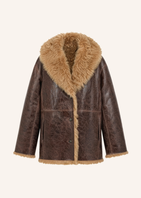 Ein dunkelbrauner Shearling-Mantel in markanter Vintage-Lederoptik mit einem voluminösen, beigefarbenen Fellkragen. Das kuschelige, helle Lammfell blitzt an der Knopfleiste, am Saum und an den weiten Ärmelabschlüssen stilvoll hervor.