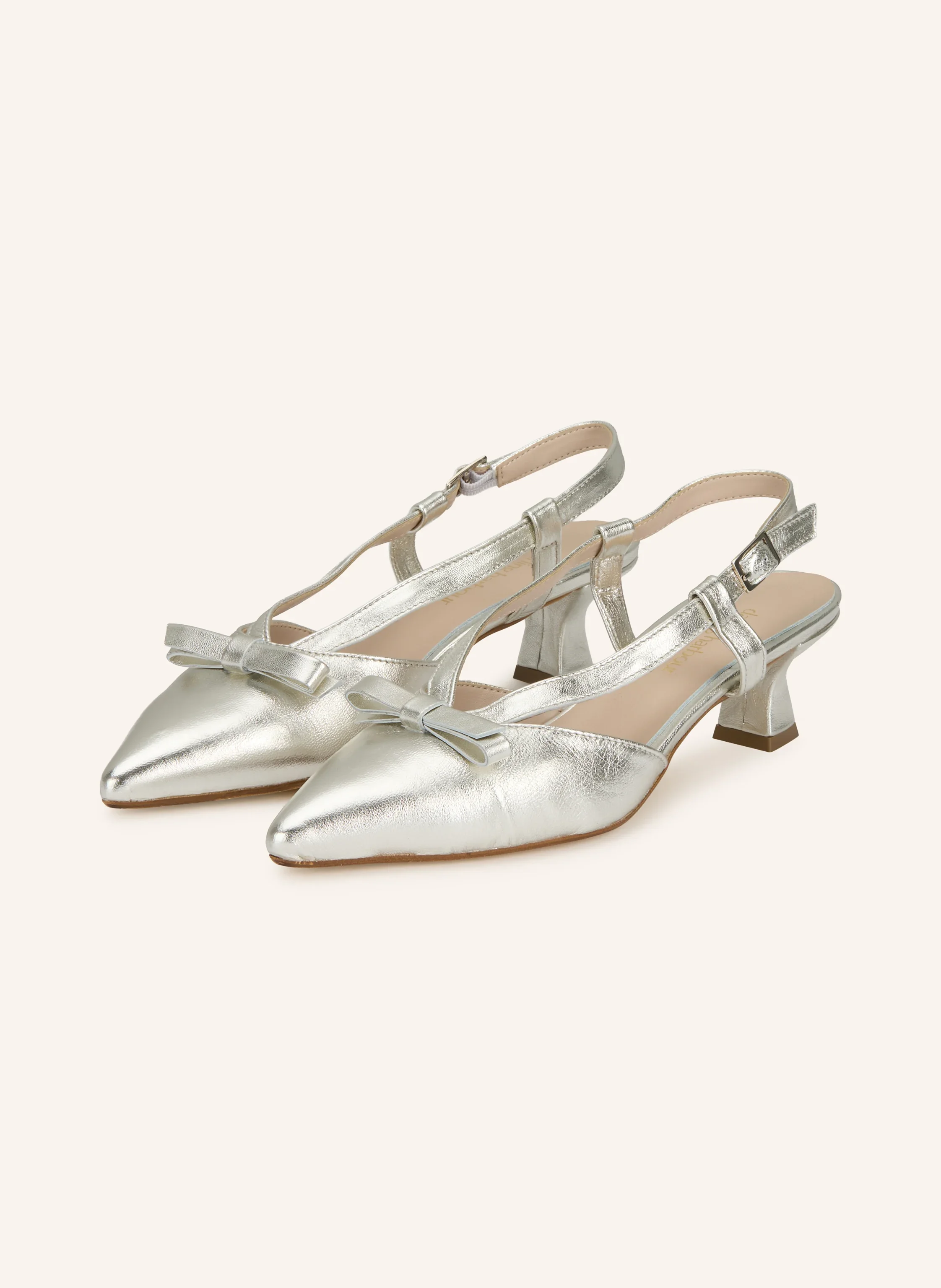 Silberne Metallic-Slingback-Pumps mit spitzer Zehenkappe, kleiner Schleife und niedrigem Blockabsatz vor hellem Hintergrund.