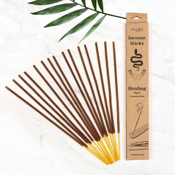 Myga Räucherstäbchen „Healing“ mit Myrrhe-Duft, fächerförmig ausgelegt auf Marmorhintergrund, daneben die minimalistische Kraftpapierverpackung.
