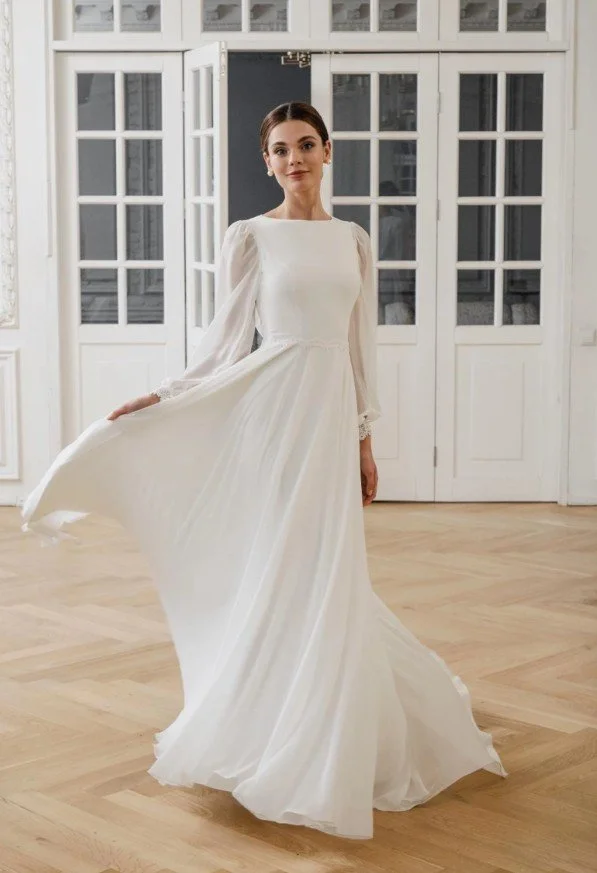 Brautkleid in A-Linie mit langen, transparenten Bischofsärmeln, einem hochgeschlossenen Oberteil und einer filigranen Spitzenbordüre an der Taille.