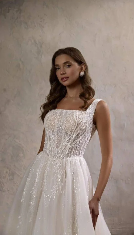 Funkelndes A-Linien Brautkleid mit quadratischem Ausschnitt, aufwendig besticktem Mieder mit Perlen und Pailletten sowie einem glitzernden Tüllrock.