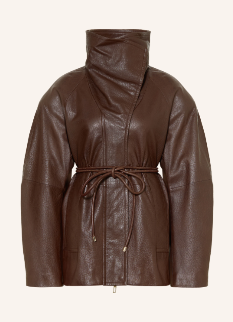 Dunkelbraune Lederjacke mit hohem, drapiertem Kragen vor hellem Hintergrund. Taillierte Damenjacke mit strukturierter Oberfläche, feinem Bindegürtel und voluminösen Ärmeln.