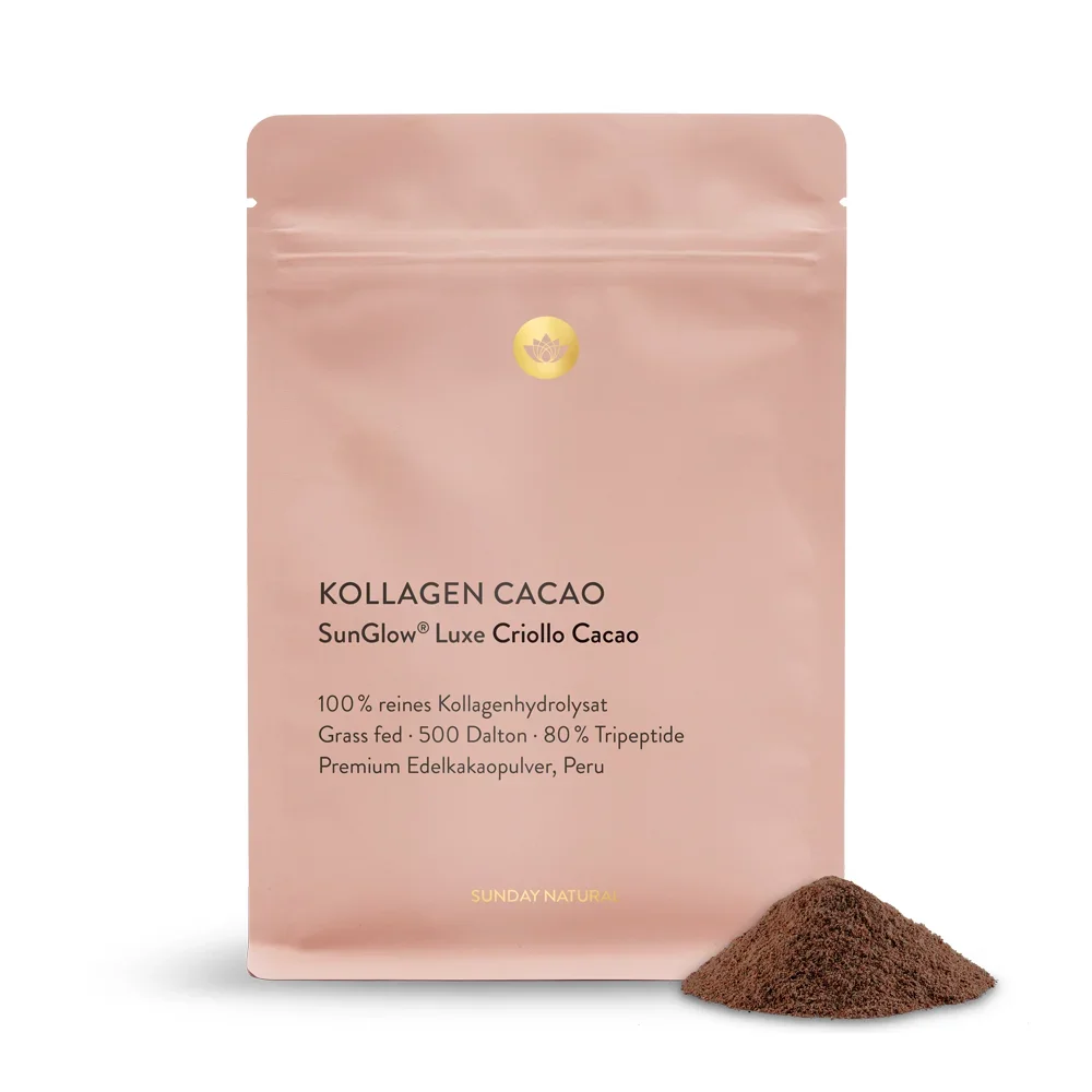 Zartrosa Beutel des "Kollagen Cacao" (SunGlow Luxe Criollo Cacao) von Sunday Natural mit einem kleinen Häufchen des dunklen, kakaohaltigen Pulvers daneben.